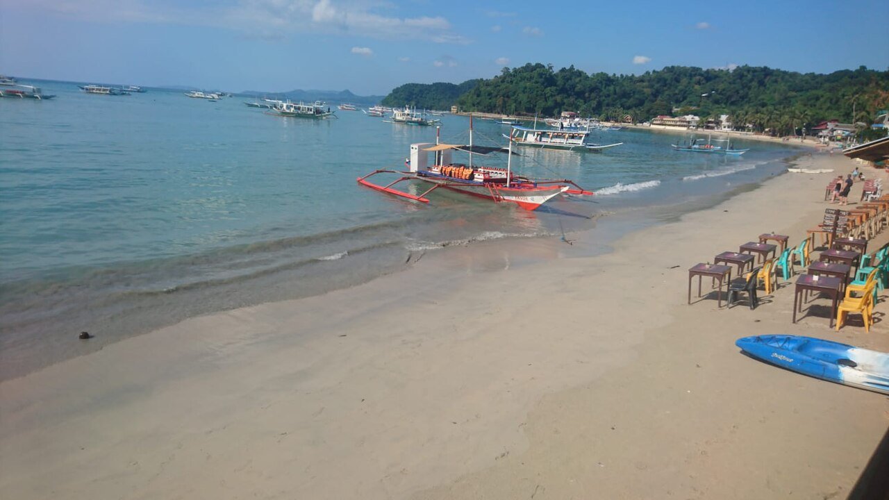 The beachfront in El Nido town with limestone cliffs behind